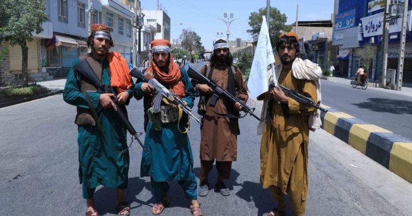 Taliban fighters are seen standing in a road in Herat, Afghanistan, on Thursday.