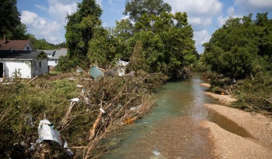 The aftermath of Trace Creek in Waverly, Tennessee, having risen to deadly levels after heavy rains over the weekend, is depicted in this Monday photo.