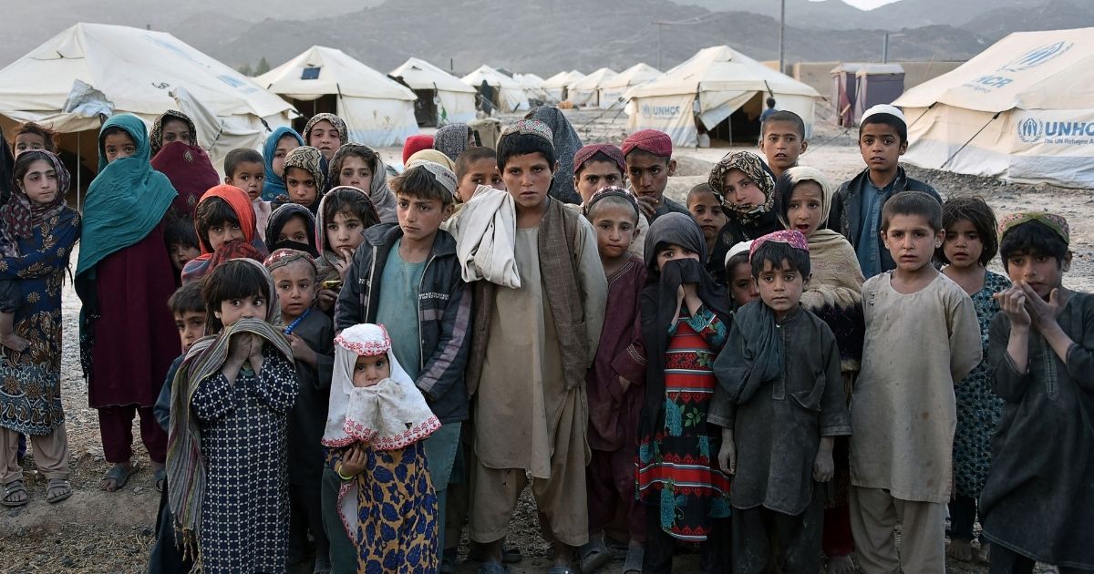 Children stand in front of tents in the Panjwai district of the Kandahar province in Afghanistan on March 31, 2021.