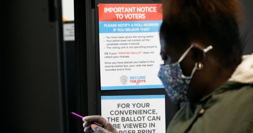 A female voter is seen casting a ballot in a voting booth in Atlanta, Georgia, on Nov. 3, 2020.