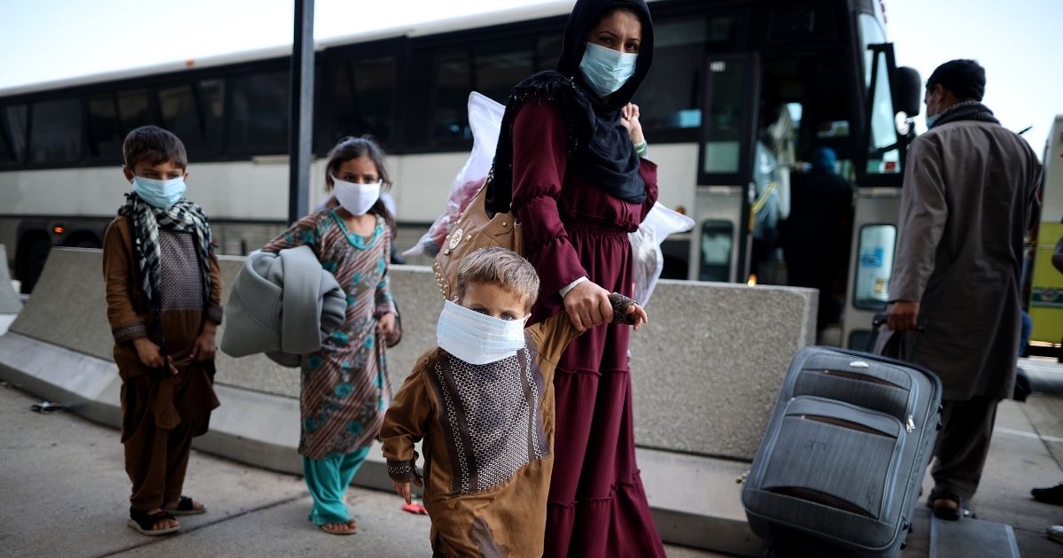 Refugees board buses that will take them to a processing center at Dulles International Airport after being evacuated from Kabul following the Taliban takeover of Afghanistan on Friday in Dulles, Virginia.
