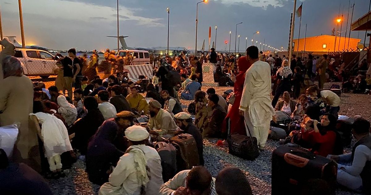 Afghan people wait to board a U.S. military aircraft to leave Afghanistan, at the military airport in Kabul on Aug. 19, after Taliban's military takeover of Afghanistan.