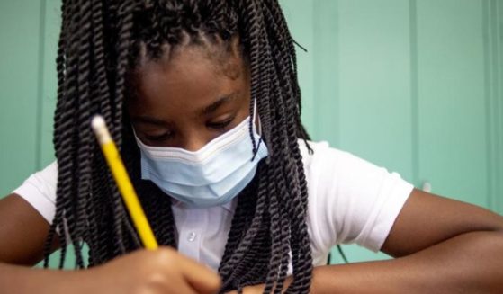 Sixth-grade student Adriana Campbell is seen wearing a mask while writing at Freeman Elementary School in Flint, Michigan in a photo taken on Wednesday.