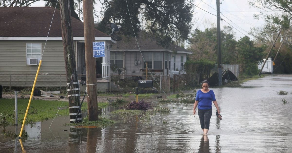 Angelina Coxum walks down a flooded street to check on a relatives home after Hurricane Ida passed through on Aug. 30, in Kenner, Louisiana.