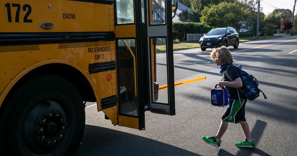 A second grade student is seen walking onto a school bus in Stamford, Connecticut, on Sept. 23, 2020.