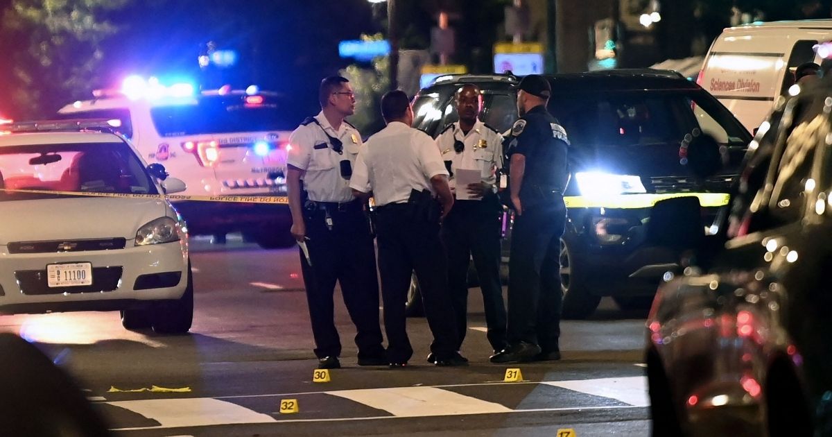 Police officers work at the scene of a shooting outside a restaurant in Washington, D.C., on July 22, 2021.