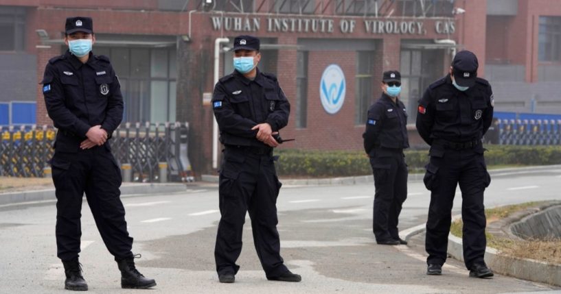 Security personnel gather near the entrance of the Wuhan Institute of Virology during a visit by the World Health Organization team in Wuhan in China's Hubei province on Feb. 3, 2021.