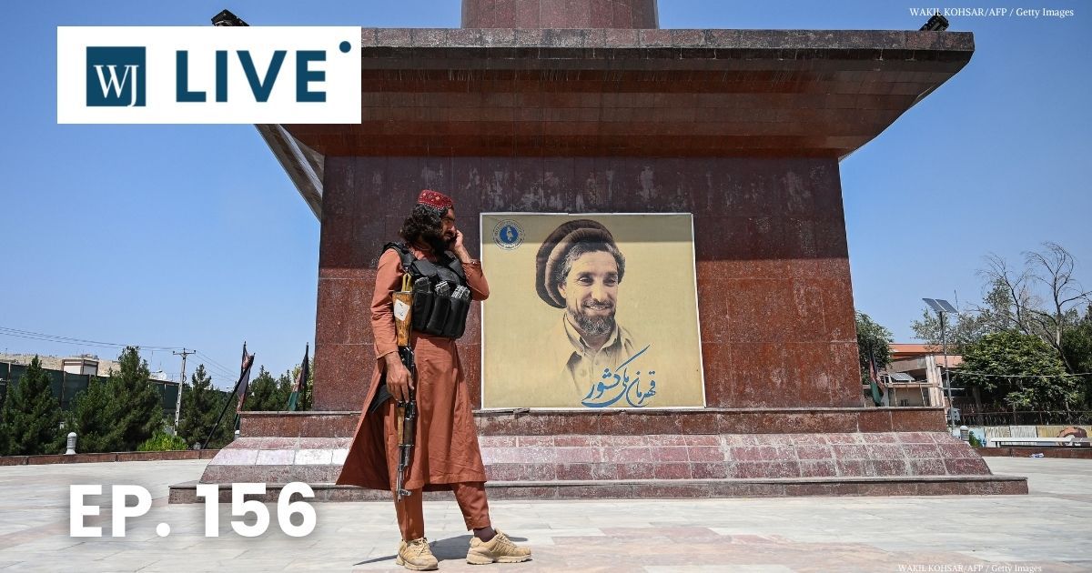 A Taliban fighter stands next to poster bearing the image late Afghan commander Ahmad Shah Massoud at the Massoud Square in Kabul on Monday.