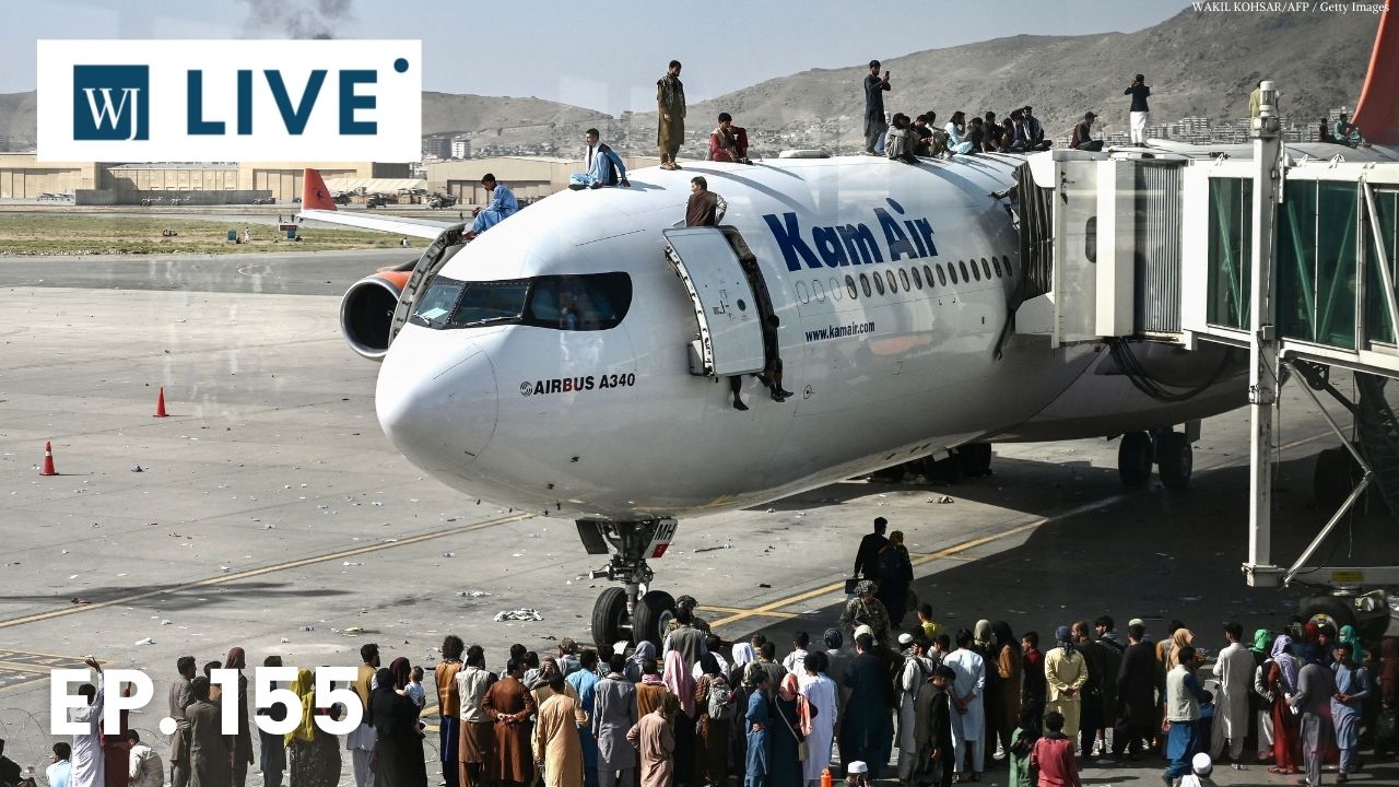 Afghan people climb atop a plane as they wait at the Kabul airport in Kabul on Monday.