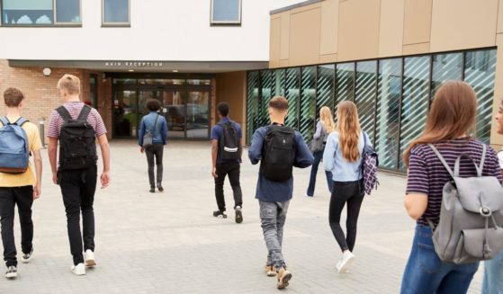 Students are seen walking into a school in the above stock image.