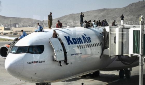 Afghans swarm over an airliner at the Kabul airport on Sunday as the Taliban takeover of the capital brings panicked anarchy.