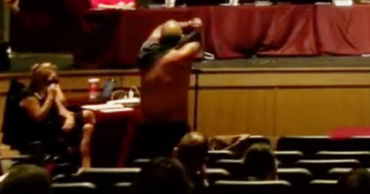 A man peels off his shirt during a school board meeting in Dripping Springs, Texas, last week.