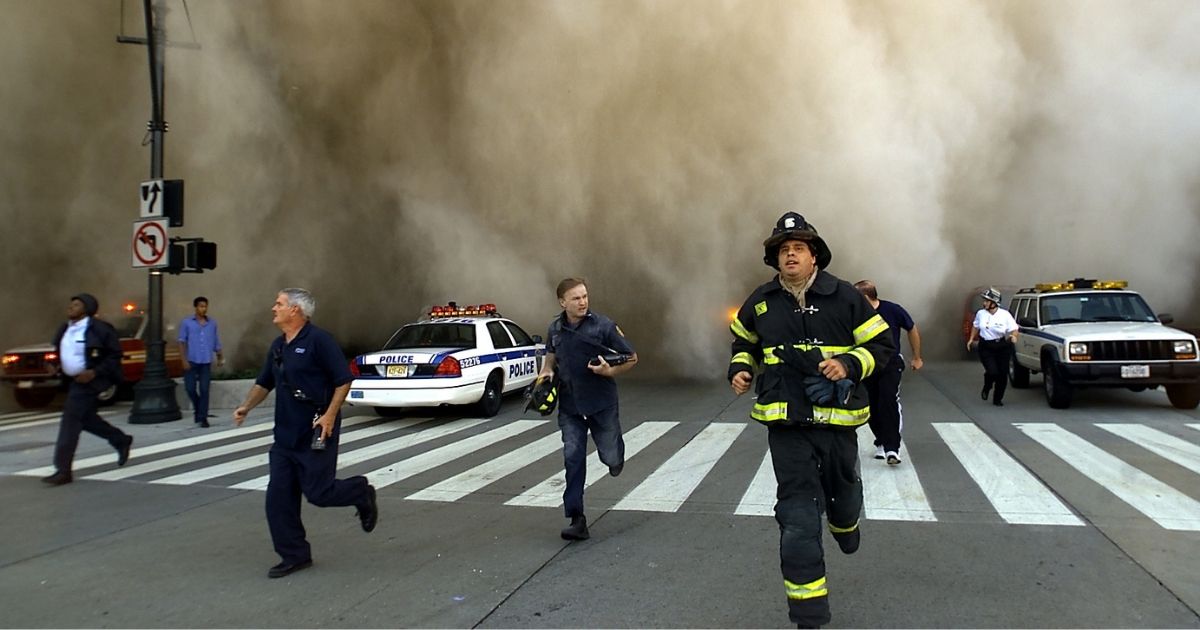 Policemen and firemen run away from a huge dust cloud after terrorists crashed two hijacked airplanes into the twin towers of the World Trade Center on Sept. 11, 2001, in New York City.