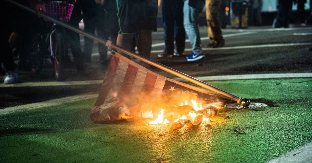 Protesters burn an American flag in Portland, Oregon, on Nov. 4, 2020, during a Black Lives Matter demonstration.