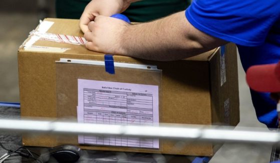 A contractor working for Cyber Ninjas, who was hired by the Arizona State Senate, unboxes ballots from the 2020 general election at Veterans Memorial Coliseum on May 1, 2021, in Phoenix.