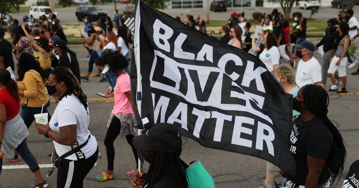 Protesters march with a Black Lives Matter banner on April 29, 2021, in Elizabeth City, North Carolina.