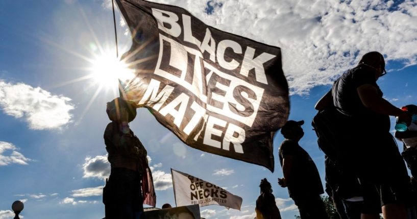 A woman holds a Black Lives Matter flag during a protest outside the Minnesota State Capitol on May 24, 2021 in Saint Paul, Minnesota.
