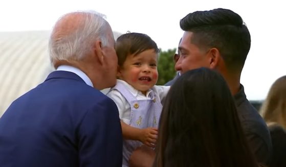 President Joe Biden leans in to kiss a baby during a visit to Colorado.