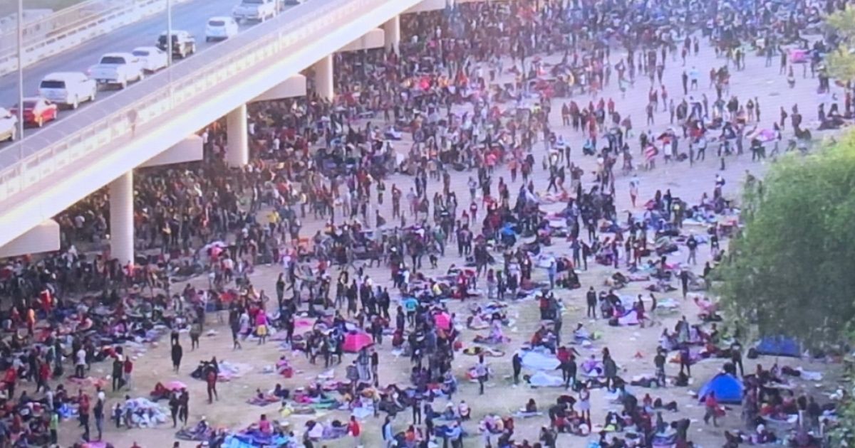 Migrants wait to be processed underneath the international bridge in Del Rio, Texas, on Thursday.