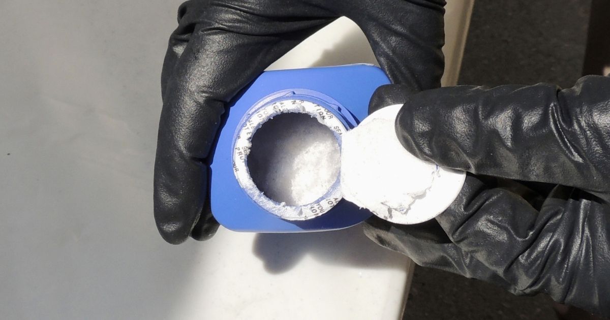 A member of the Royal Canadian Mounted Police opens a printer ink bottle containing the opioid carfentanil, imported from China, in Vancouver on June 27, 2016.