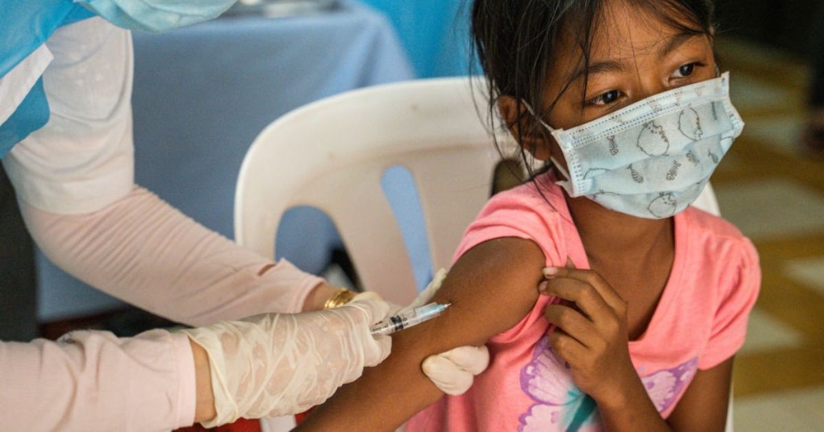 A child receives a dose of the Sinovac COVID-19 vaccine at a health center on Saturday in Phnom Penh, Cambodia.