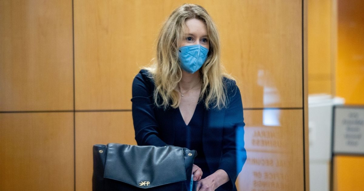 Theranos founder Elizabeth Holmes collects her belongings after going through security at the Robert F. Peckham Federal Building with her defense team on Tuesday in San Jose, California.