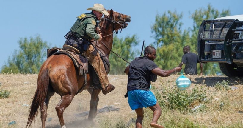 A United States Border Patrol agent on horseback uses the reins to try and stop a Haitian migrant from entering an encampment on the banks of the Rio Grande near the Acuna Del Rio International Bridge in Del Rio, Texas, on Sept. 19, 2021.