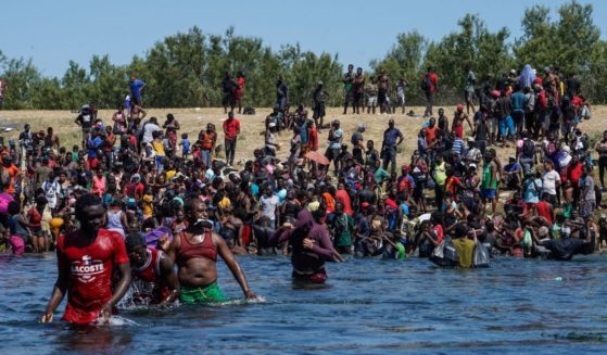 Haitian migrants, part of a group of over 10,000 people staying in an encampment on the US side of the border, cross the Rio Grande river to get food and water in Mexico, after another crossing point was closed near the Acuna Del Rio International Bridge in Del Rio, Texas on Sept. 19, 2021.