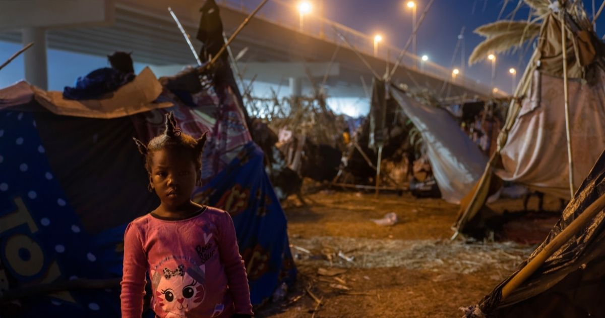 A Haitian girl stands at a migrant camp at the U.S.-Mexico border on Tuesday in Del Rio, Texas.