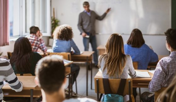 Students are pictured in a high school classroom in the stock image above.