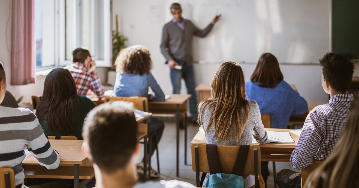 Students are pictured in a high school classroom in the stock image above.