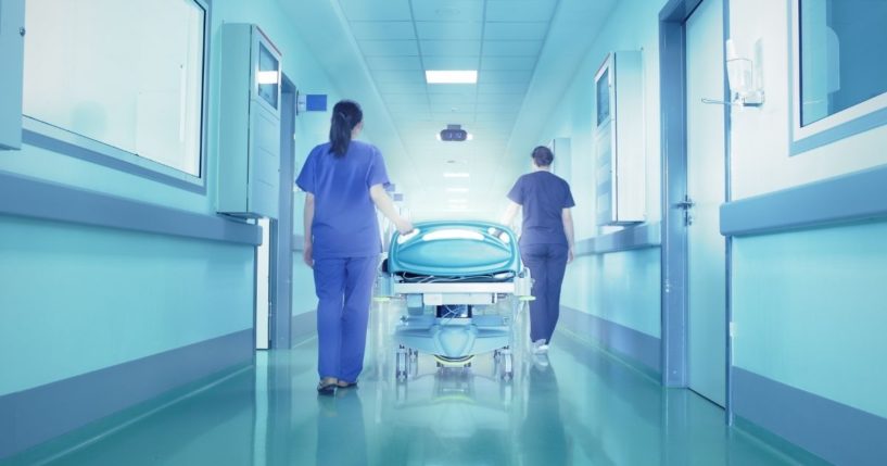 Nurses are pictured in a hospital hallway in the stock image above.