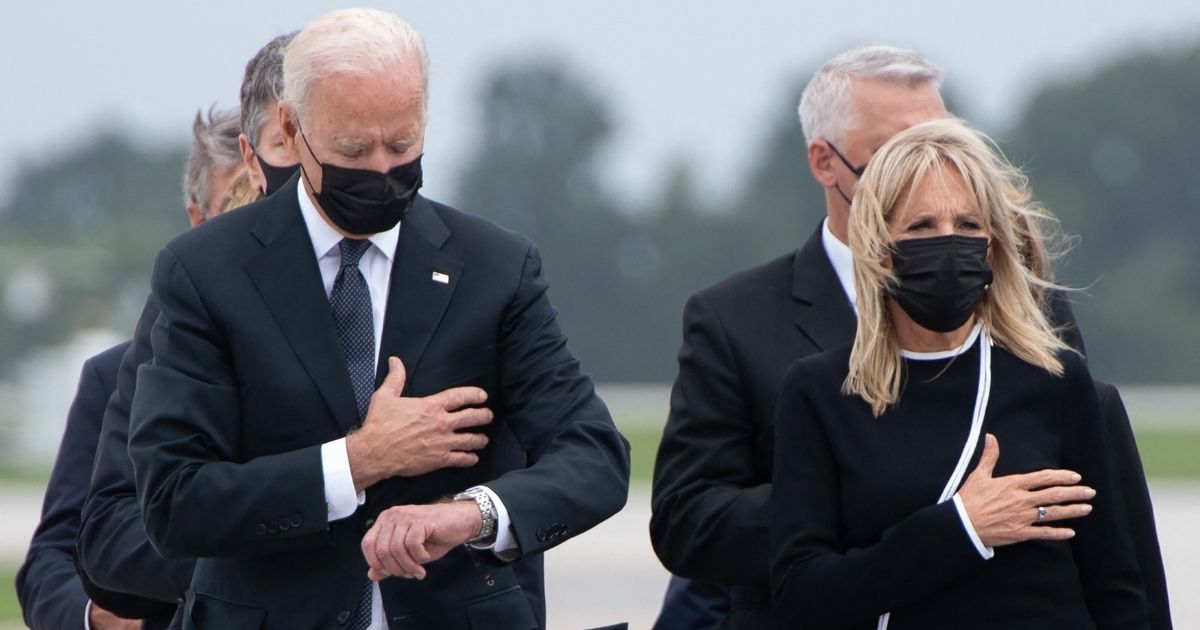 President Joe Biden glances at his watch during a dignified transfer of the remains of a fallen service member at Dover Air Force Base in Dover, Delaware, on Sunday.