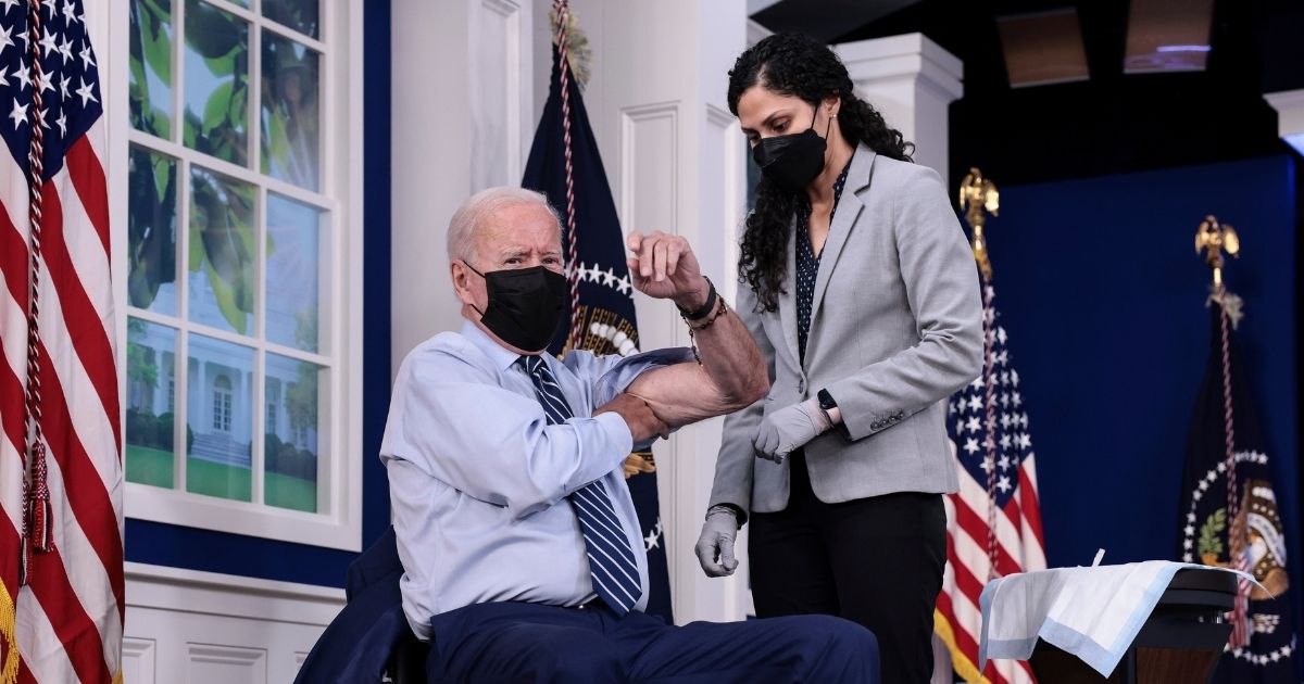 President Joe Biden rolls up his sleeve before receiving a third dose of the Pfizer-BioNTech COVID-19 vaccine at the White House on Monday.