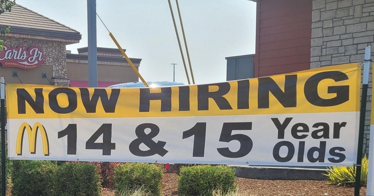 A banner outside a McDonald's advertises job openings available to 14- and 15-year-olds.
