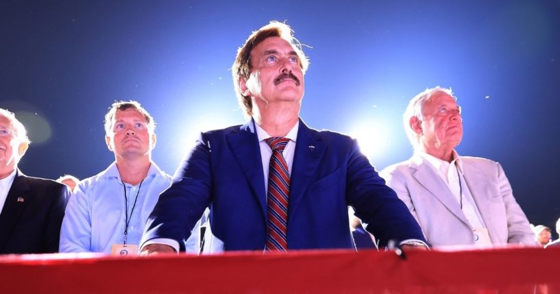 Mike Lindell. founder and CEO of MyPillow, listens as former President Donald Trump addresses supporters at a rally on Aug. 21, 2021, in Cullman, Alabama.