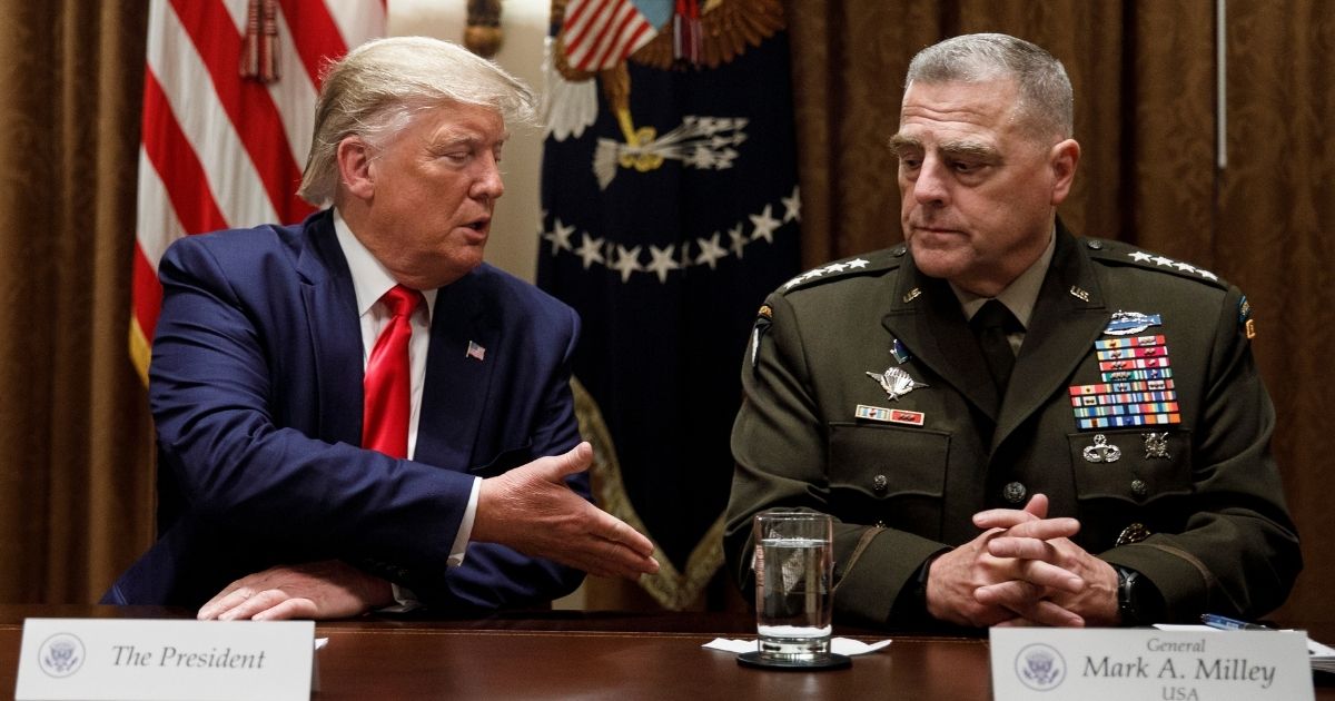 President Donald Trump extends a hand to Chairman of the Joint Chiefs of Staff Gen. Mark Milley, as he speaks to media during a briefing with senior military leaders in the Cabinet Room at the White House in Washington, D.C., on Oct. 7, 2019.