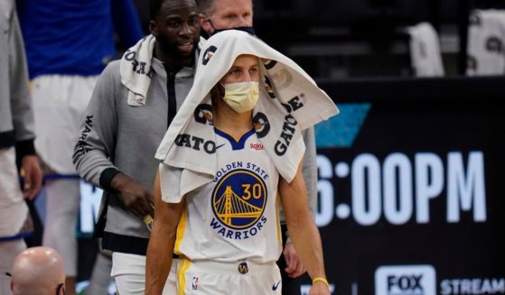 Golden State Warriors guard Stephen Curry wears a face mask to protect against the spread of COVID-19 during an NBA basketball game against the San Antonio Spurs in this file photo from Feb. 9, 2021.