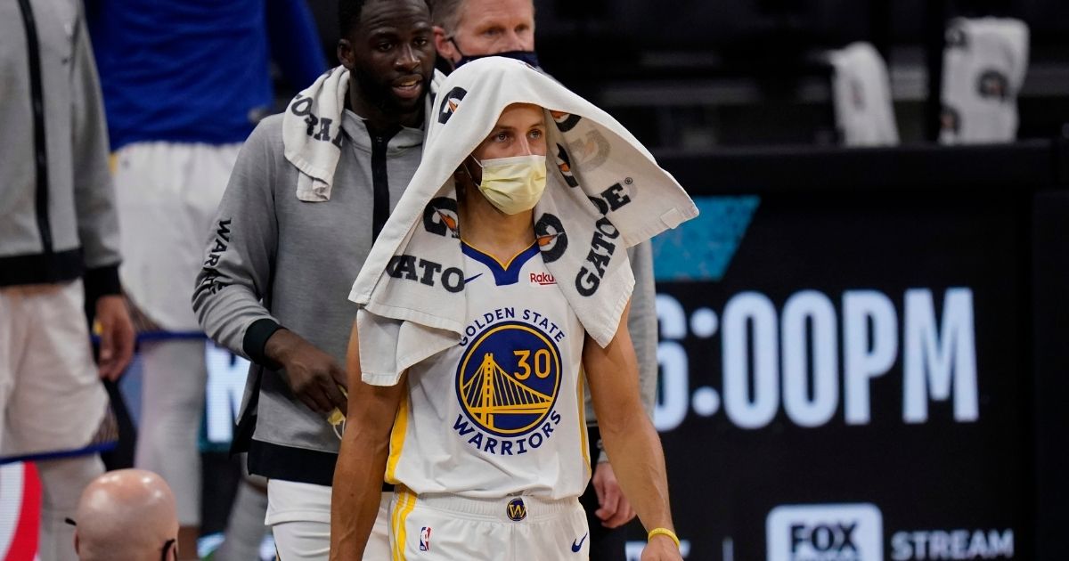 Golden State Warriors guard Stephen Curry wears a face mask to protect against the spread of COVID-19 during an NBA basketball game against the San Antonio Spurs in this file photo from Feb. 9, 2021.