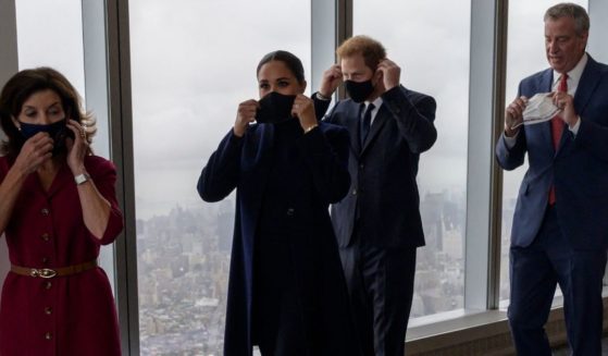 Britain's Prince Harry, center, and Meghan Markle walk with New York Gov. Kathy Hochul, left, and New York City Mayor Bill de Blasio and remove their masks for a photo op during a visit to the One World Trade Center observation deck in New York on Thursday.