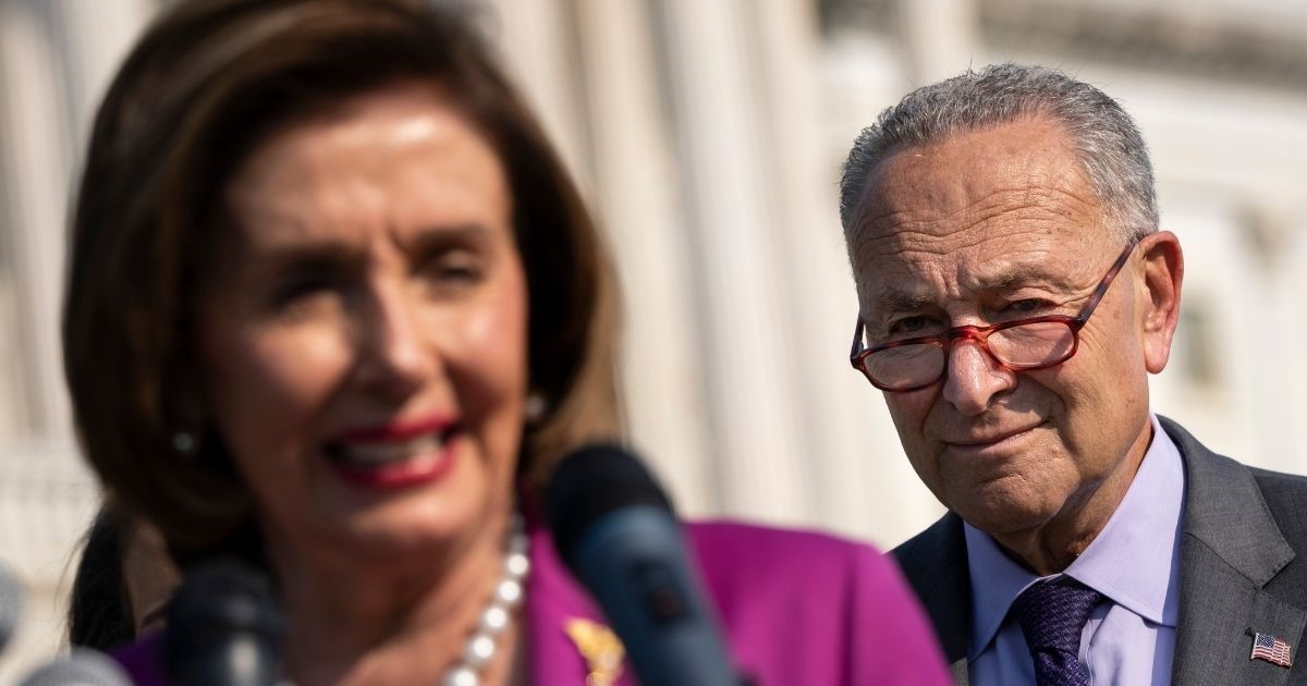 Speaker of the House Nancy Pelosi, left, speaks as Senate Majority Leader Chuck Schumer looks on during a news conference about climate change outside the U.S. Capitol on July 28, 2021, in Washington, D.C.
