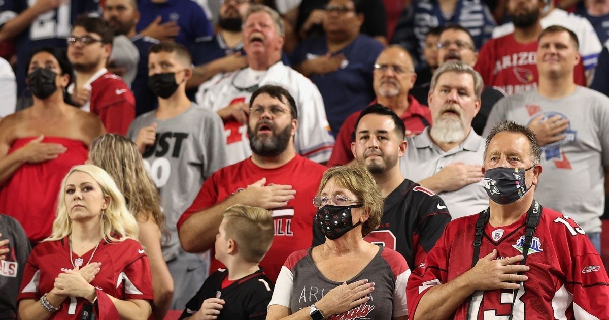 Fans stand for the national anthem before the NFL preseason game between the Arizona Cardinals and the Dallas Cowboys at State Farm Stadium on Aug. 13, 2021, in Glendale, Arizona.