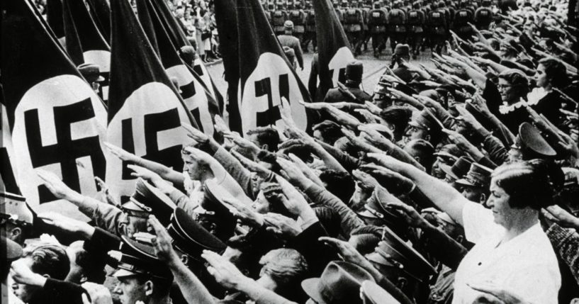 Crowds give the fascist salute while Nazi Labor Corps march past them, bearing flags with swastikas, during an annual congress for the National Socialist Party in Nuremberg, Germany.