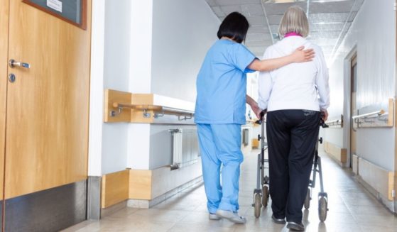 A nursing home worker is pictured with a resident in the stock image above.