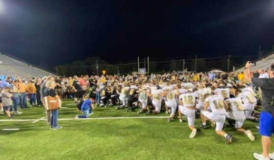 Upperman and Stone Memorial high school football players lead fans in prayer on the field after their game Friday night in Tennessee.
