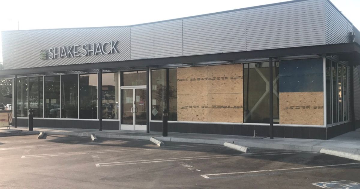 The windows at a Shake Shack in Canoga Park, Los Angeles, are boarded up after a homeless man opened fire on customers and employees inside.