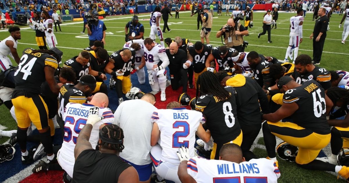 Players for the NFL's Pittsburgh Steelers and Buffalo Bills kneel and pray before their Sunday game.