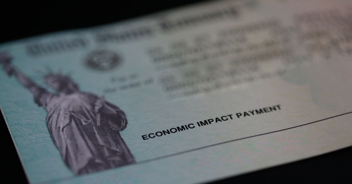An economic impact payment, also referred to as a stimulus check, issued by the United States Treasury with address and routing numbers removed is displayed on a black background on May 15, 2021, in North Las Vegas, Nevada.