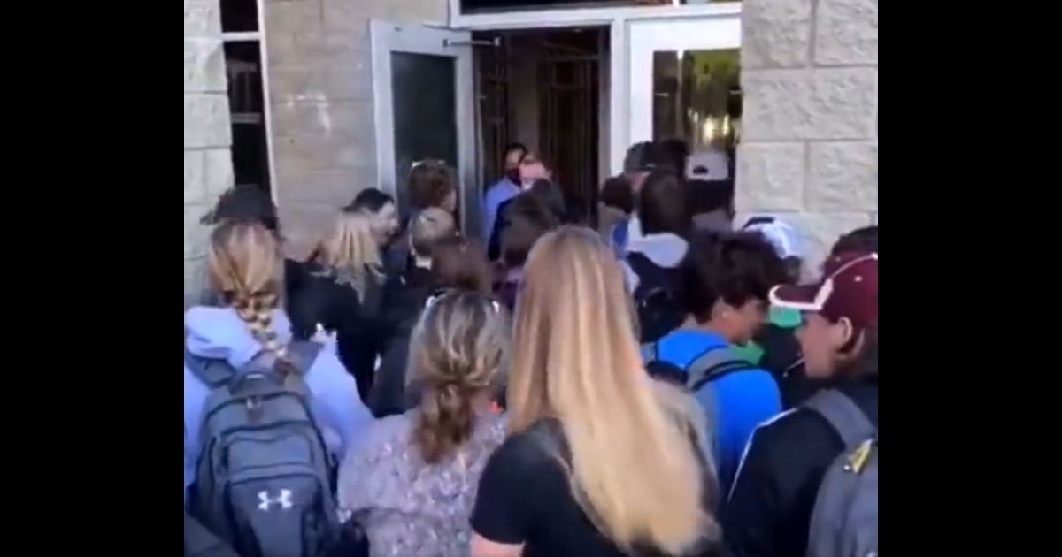 About two dozen students at Manchester High School in Michigan attempt to enter the school Tuesday in protest of the district's mask mandate.