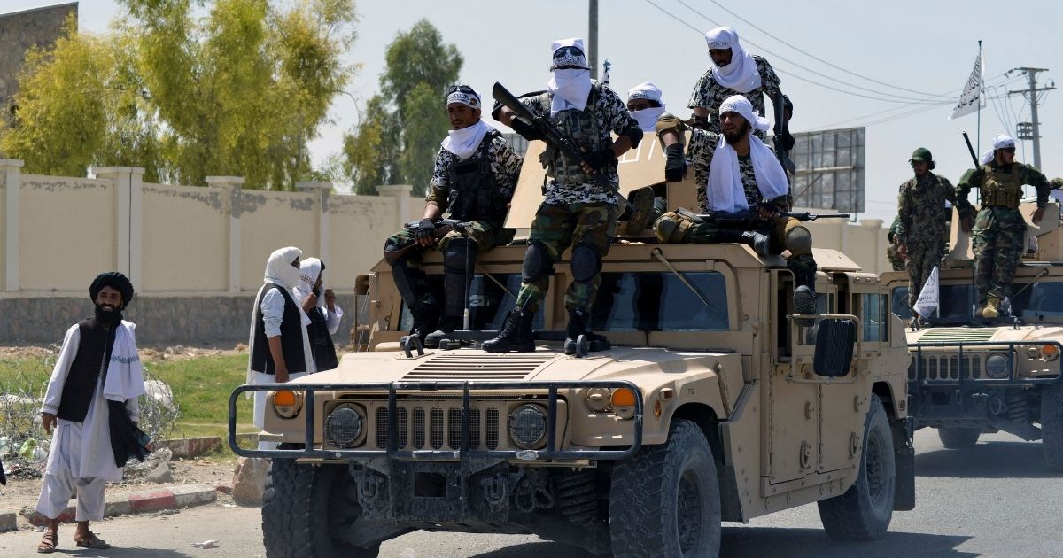 Taliban fighters atop Humvee vehicles parade along a road to celebrate after the U.S. pulled all its troops out of Afghanistan, in Kandahar on Wednesday following the Taliban's military takeover of the country.